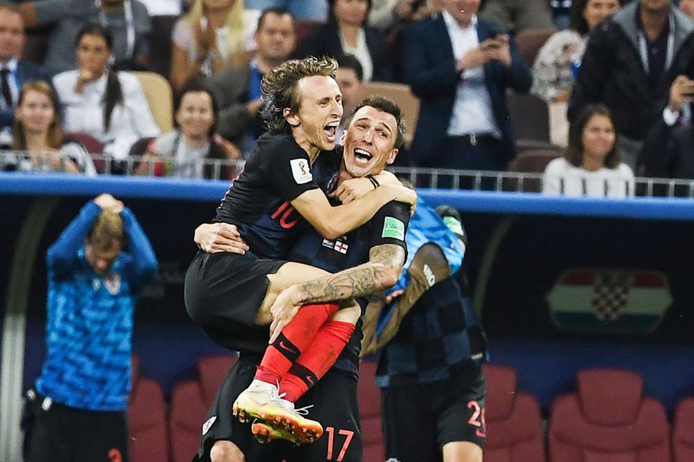 Croatia's midfielder Luka Modric and Croatia's forward Mario Mandzukic celebrate their win at the end of the Russia 2018 World Cup semi-final football match between Croatia and England at the Luzhniki Stadium in Moscow on July 11, 2018. Croatia will play France in the World Cup final after they beat England 2-1 in extra-time on Wednesday thanks to a Mario Mandzukic goal in the second period of extra-time. - RESTRICTED TO EDITORIAL USE - NO MOBILE PUSH ALERTS/DOWNLOADS

 / AFP / MANAN VATSYAYANA / RESTRICTED TO EDITORIAL USE - NO MOBILE PUSH ALERTS/DOWNLOADS

