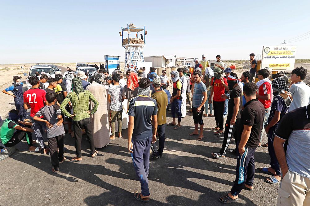 Protesters demonstrate against unemployment in front of oil fields in al-Qurnah, some 100 kilometers north of Basra, southern Iraq, on July 14, 2018. Iraqi Prime Minister Haider al-Abadi sought on July 14 to restore calm in the city of Basra after days of protests over unemployment, as demonstrations spread to other regions. / AFP / Haidar MOHAMMED ALI
