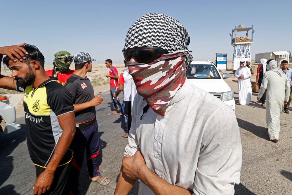 Protesters demonstrate against unemployment in front of oil fields in al-Qurnah, some 100 kilometers north of Basra, southern Iraq, on July 14, 2018. Iraqi Prime Minister Haider al-Abadi sought on July 14 to restore calm in the city of Basra after days of protests over unemployment, as demonstrations spread to other regions. / AFP / Haidar MOHAMMED ALI
