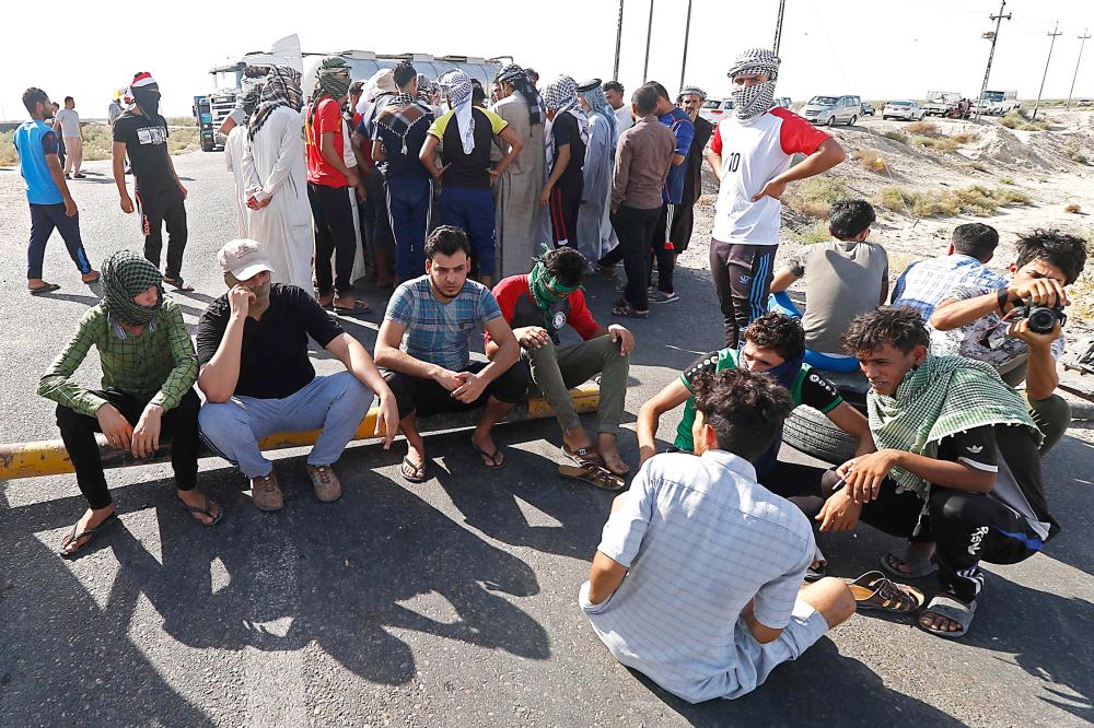 Protesters demonstrate against unemployment in front of oil fields in al-Qurnah, some 100 kilometers north of Basra, southern Iraq, on July 14, 2018. Iraqi Prime Minister Haider al-Abadi sought on July 14 to restore calm in the city of Basra after days of protests over unemployment, as demonstrations spread to other regions. / AFP / Haidar MOHAMMED ALI
