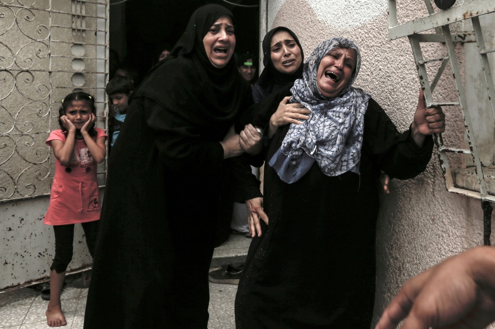 Palestinians and relatives mourn over the death of 15-year-old protester Othman Rami Halles during his funeral east of Gaza City on July 14, 2018. A Palestinian teenager was shot dead Friday by Israeli soldiers during clashes near the Gaza Strip's border with Israel, the territory's health ministry said. Fifteen-year-old Othman Rami Halles was killed east of Gaza City, while 25 other Palestinians were wounded as protests along the frontier spilt over into clashes, ministry spokesman Ashraf Al-Qodra said. 
 / AFP / MAHMUD HAMS
