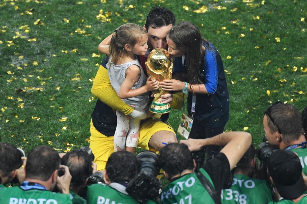 France's goalkeeper Hugo Lloris (C) kisses the trophy with his daughters as they celebrate during the trophy ceremony after winning the Russia 2018 World Cup final football match between France and Croatia at the Luzhniki Stadium in Moscow on July 15, 2018. RESTRICTED TO EDITORIAL USE - NO MOBILE PUSH ALERTS/DOWNLOADS

 / AFP / GABRIEL BOUYS / RESTRICTED TO EDITORIAL USE - NO MOBILE PUSH ALERTS/DOWNLOADS

