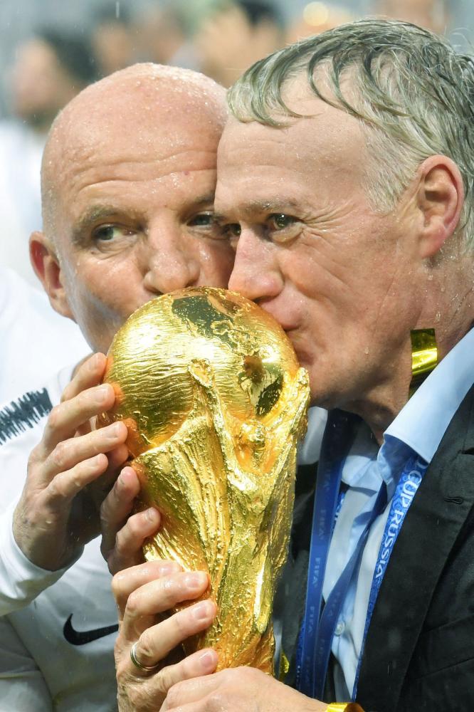 France's coach Didier Deschamps (C) kisses the trophy at the end of the Russia 2018 World Cup final football match between France and Croatia at the Luzhniki Stadium in Moscow on July 15, 2018. RESTRICTED TO EDITORIAL USE - NO MOBILE PUSH ALERTS/DOWNLOADS

 / AFP / Kirill KUDRYAVTSEV / RESTRICTED TO EDITORIAL USE - NO MOBILE PUSH ALERTS/DOWNLOADS

