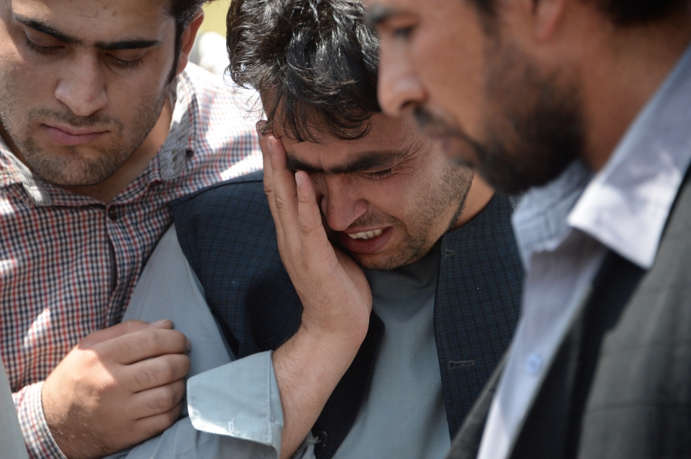 People react at the burial ceremony of AFP driver Mohammad Akhtar in Kabul on July 23, 2018, a day after he was killed in a suicide attack in the Afghan capital. AFP driver Mohammad Akhtar, a 31-year-old father of four who was among 23 people killed in a suicide attack in Kabul, was a «great friend» known for his kindness and honesty, colleagues said July 23.
 / AFP / NOORULLAH SHIRZADA
