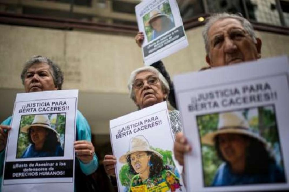 People protest against the murder of Honduran environmental activist Berta Caceres in front of the Honduran embassy in Santiago on March 7, 2016. Caceres, a respected environmentalist who won the prestigious Goldman Prize last year for her outspoken advocacy, was murdered in her home last week.   AFP PHOTO / MARTIN BERNETTI / AFP PHOTO / MARTIN BERNETTI