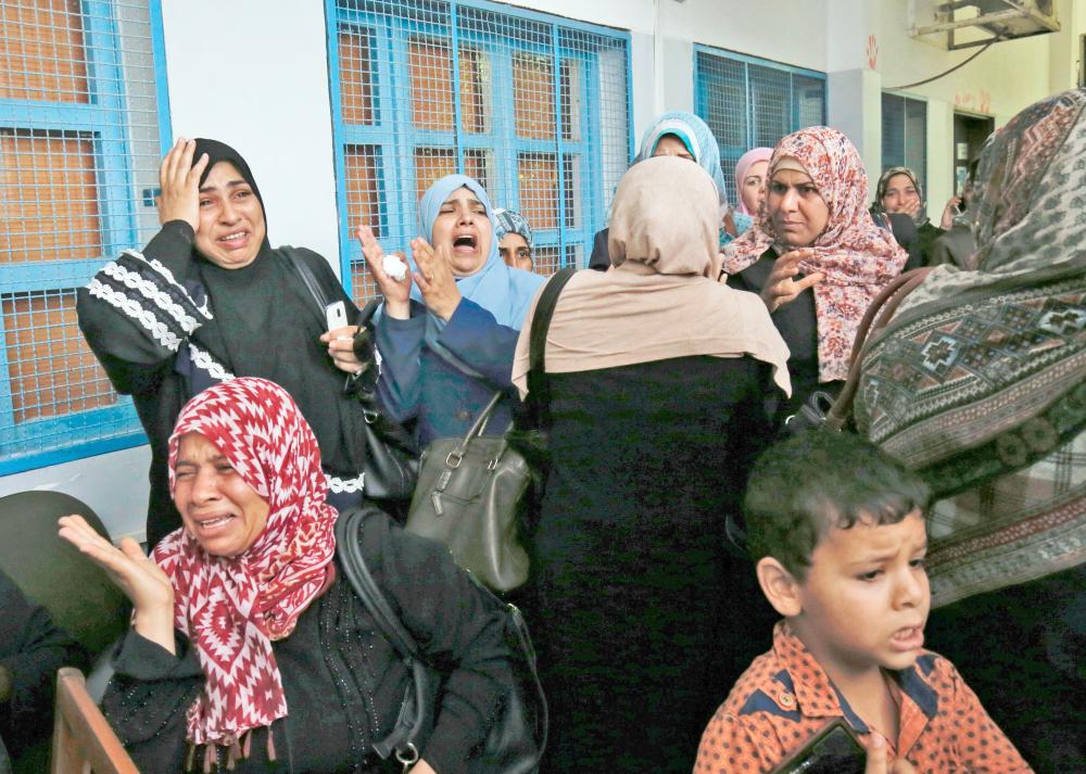 Palestinian employees of the United Nations agency for Palestinian refugees UNRWA take part in a protest against job cuts announced by the agency,  at its headquarters in Gaza City July 25, 2018. UNRWA announced today that it was cutting more than 250 jobs in the Palestinian territories after the United States held back hundreds of millions in aid.  / AFP / SAID KHATIB
