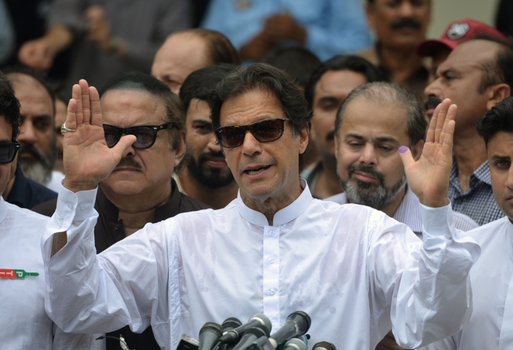 Pakistan's cricketer-turned politician Imran Khan of the Pakistan Tehreek-e-Insaf (Movement for Justice) speaks to the media after casting his vote at a polling station during the general election in Islamabad on July 25, 2018. Pakistanis voted July 25 in elections that could propel former World Cup cricketer Imran Khan to power, as security fears intensified with a voting-day blast that killed at least 30 after a campaign marred by claims of military interference. / AFP / AAMIR QURESHI
