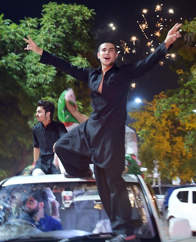 Supporters of Pakistan's cricketer-turned politician Imran Khan, head of the Pakistan Tehreek-e-Insaf (Movement for Justice) party, celebrate on a street during general election in Islamabad on July 25, 2018.

 Pakistan's incumbent party rejected early election results Thursday that suggested former cricket hero Imran Khan was on his way to becoming the country's next prime minister, alleging «blatant» rigging. 

 / AFP / AAMIR QURESHI
