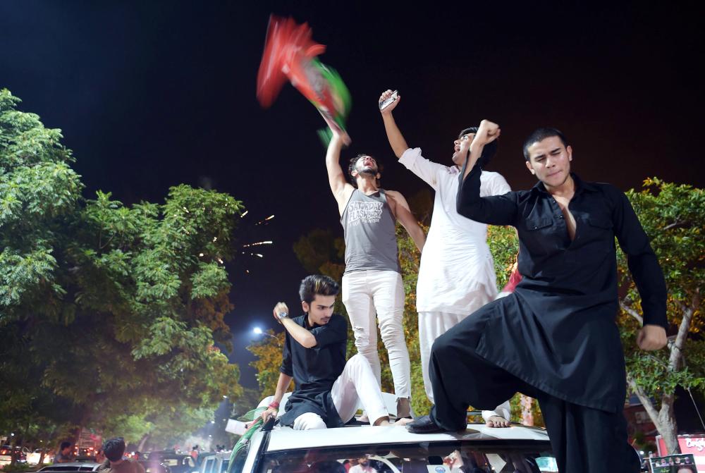 Supporters of Pakistan's cricketer-turned politician Imran Khan, head of the Pakistan Tehreek-e-Insaf (Movement for Justice) party, celebrate on a street during general election in Islamabad on July 25, 2018.

 Pakistan's incumbent party rejected early election results Thursday that suggested former cricket hero Imran Khan was on his way to becoming the country's next prime minister, alleging «blatant» rigging. 

 / AFP / AAMIR QURESHI
