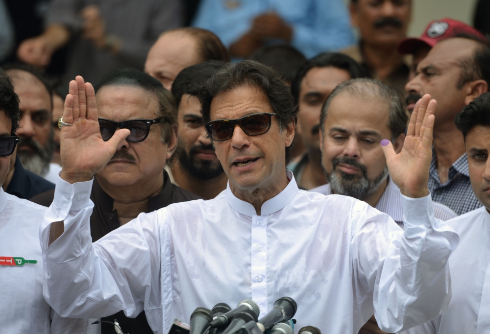 TOPSHOT - Pakistan's cricketer-turned politician Imran Khan of the Pakistan Tehreek-e-Insaf (Movement for Justice) speaks to the media after casting his vote at a polling station during the general election in Islamabad on July 25, 2018. Pakistanis voted July 25 in elections that could propel former World Cup cricketer Imran Khan to power, as security fears intensified with a voting-day blast that killed at least 30 after a campaign marred by claims of military interference. / AFP / AAMIR QURESHI
