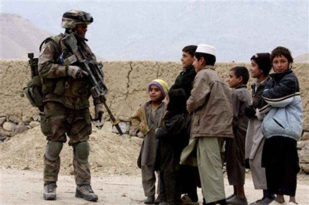 A French Foreign Legion soldier talks to children in the remote village of Saeb Zada in eastern Afghanistan on Wednesday, Dec. 9, 2009. The French NATO forces in charge of this volatile district of the Kapisa region are vying for influence with insurgents in the area. (AP Photo / Alfred de Montesquiou.) 