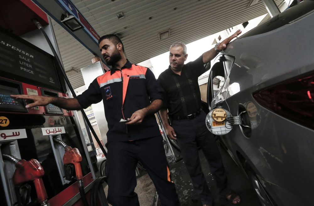 

A Palestinian worker helps a client pay before filling his car with petrol at a gas station in Gaza City on August 2, 2018, hours after Israel's decision again to halt fuel shipments through its only goods crossing with Gaza partly due to a resurgence in kites carrying firebombs over the border, signalling a brief pause in tensions may be ending. / AFP / MAHMUD HAMS

368/5000
عامل فلسطيني يملأ سيارة بالبنزين في غزة أمس بعد ساعات من قرار إسرائيل وقف شحنات الوقود. / أ ف ب /
