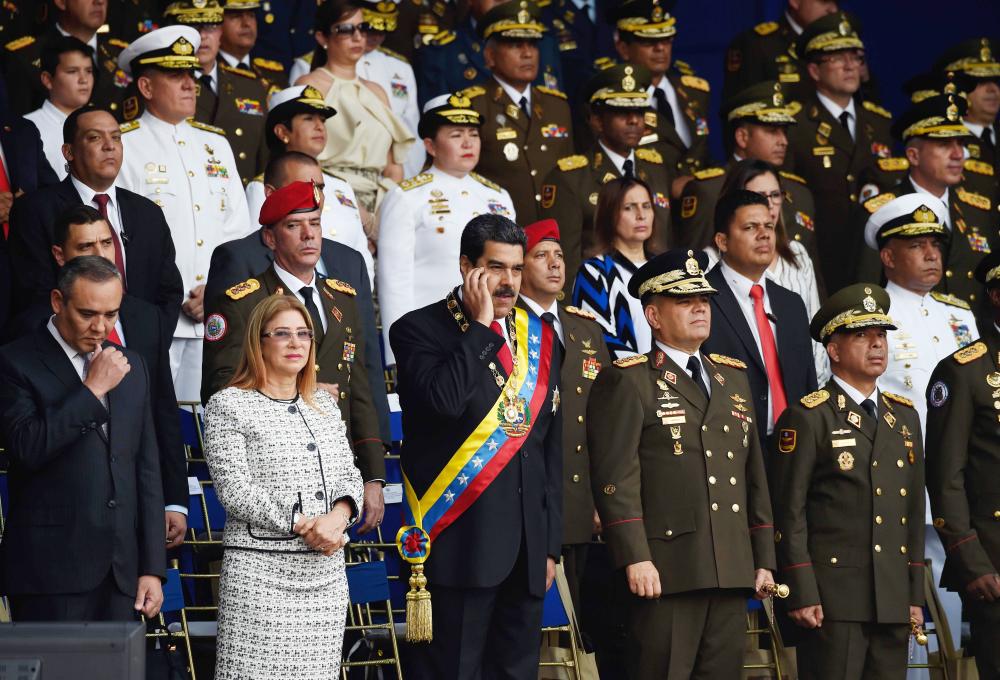 Venezuelan President Nicolas Maduro (C) gestures next to his wife Cilia Flores (2-L) during a ceremony in support of the National Guard in Caracas on August 4, 2018 day in which Venezuela's controversial Constituent Assembly marks its first anniversary. The Constituent Assembly marks its first anniversary on August 4 as the embodiment of Maduro's entrenchment in power despite an economic crisis that has crippled the country's public services and destroyed its currency. The assembly's very creation last year was largely responsible for four months of street protests that left some 125 people dead.
 / AFP / Juan BARRETO
