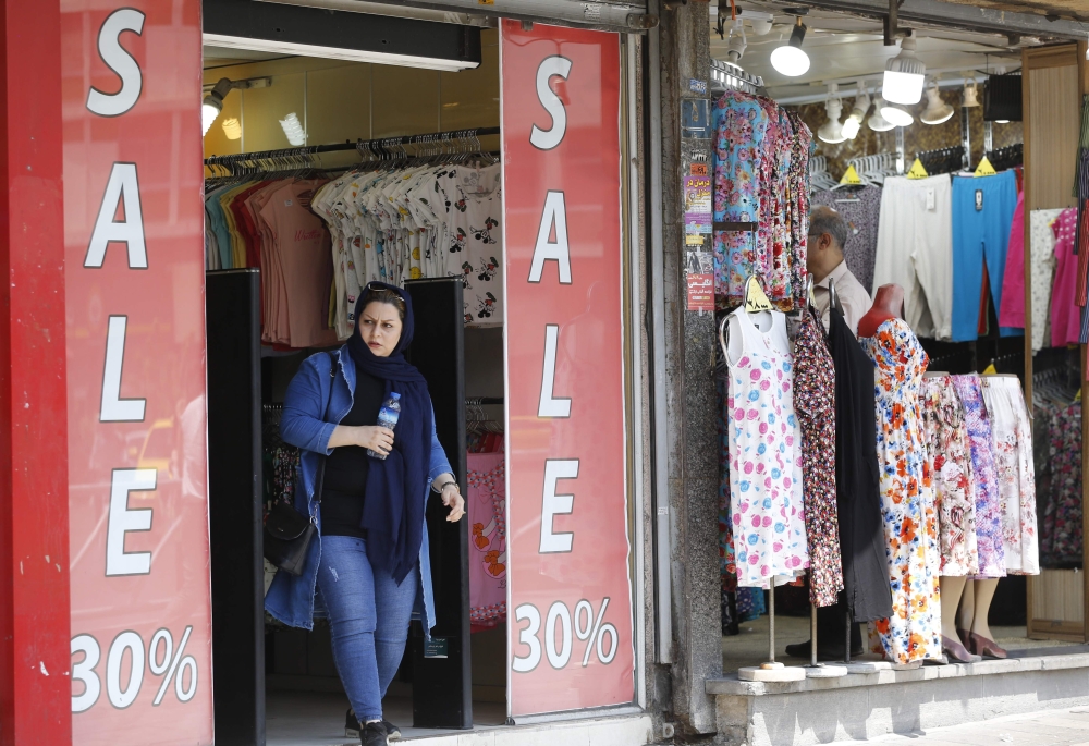 An Iranian woman walk out of a ladies clothing shop in central Tehran on August 6, 2018. Iranian Foreign Minister Mohammad Javad Zarif said today that the leaders of the United States, Saudi Arabia and Israel were isolated in their hostility to Iran. / AFP / ATTA KENARE
