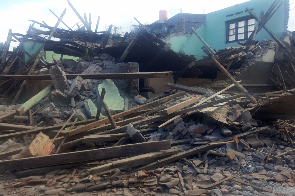 TOPSHOT - A collapsed home is seen in Batuyang village in Lombok on August 6, 2018, a day after a 6.9 magnitude earthquake struck the area. Indonesia evacuated hundreds of tourists from popular resorts and sent rescuers fanning across the holiday island of Lombok on august 6, 2018 after a powerful quake killed at least 91 people and reduced thousands of buildings to rubble.
 / AFP / Gin Sugi
