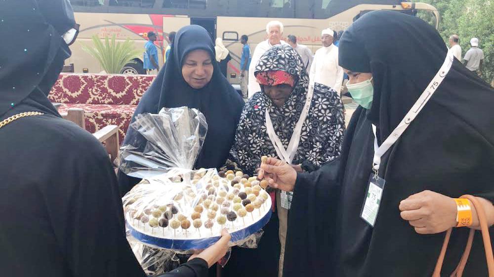 



مطوفات من حجاج الدول العربية يستقبلن الضيوف بالحلوى والتمر.