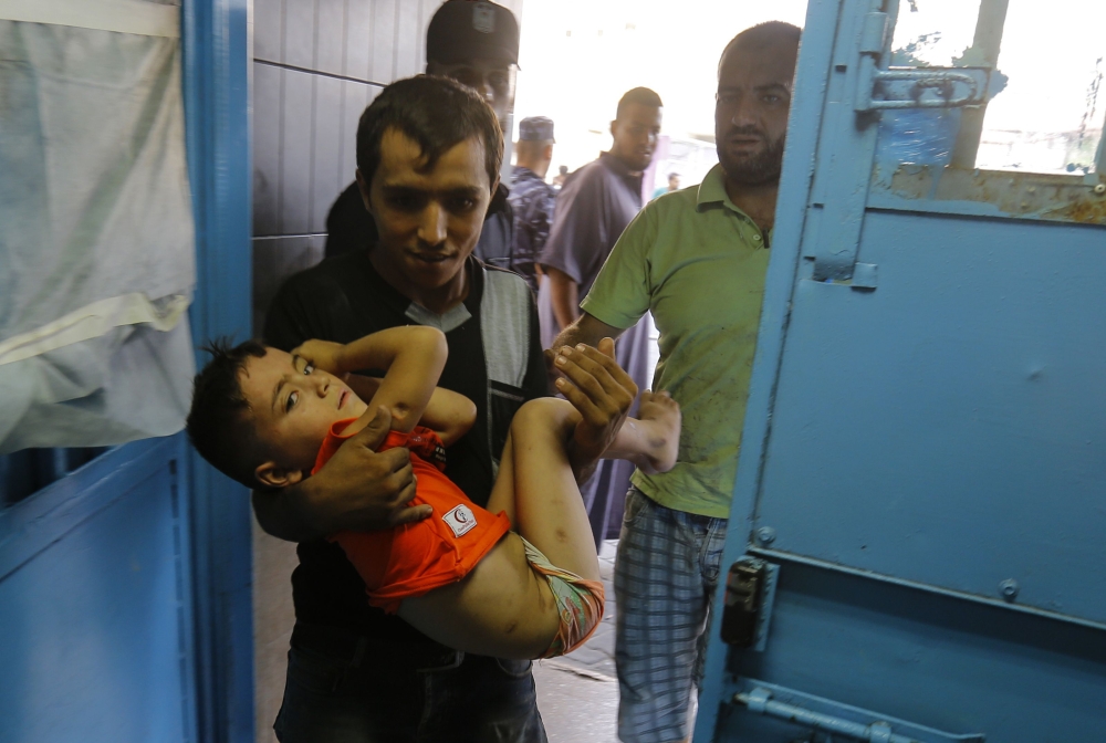 A wounded Palestinian boy is brought into al-Shifa hospital on August 9, 2018, following an Israeli air strike on Gaza City. At least 18 Palestinians were wounded as Israel struck a building in central Gaza City, the health ministry in the Palestinian enclave said, after hours of relative calm. The strike hit a building that Palestinians say housed a cultural centre and other offices in the middle of the city, an AFP correspondent said. Israel's military had not commented. / AFP / ANAS BABA
