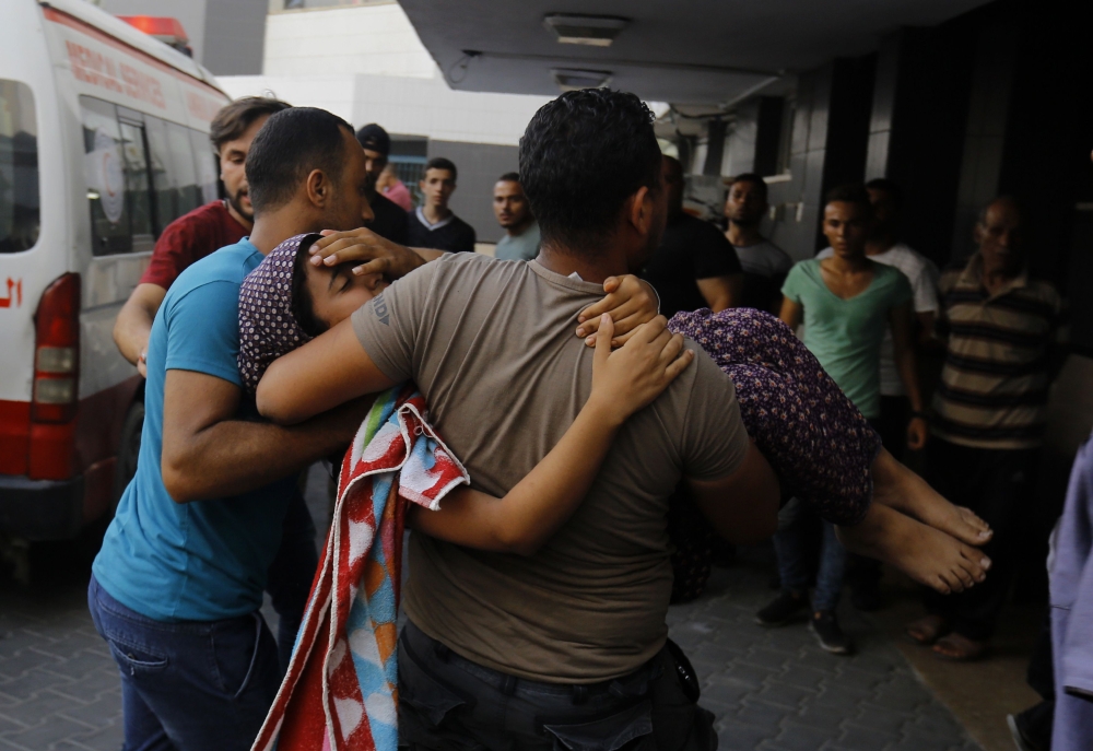 A wounded Palestinian girl is brought into al-Shifa hospital on August 9, 2018, following an Israeli air strike on Gaza City. At least 18 Palestinians were wounded as Israel struck a building in central Gaza City, the health ministry in the Palestinian enclave said, after hours of relative calm. The strike hit a building that Palestinians say housed a cultural centre and other offices in the middle of the city, an AFP correspondent said. Israel's military had not commented. / AFP / ANAS BABA
