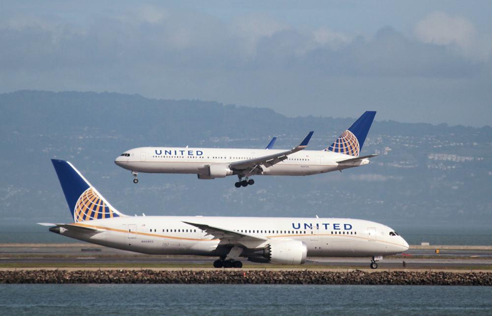 FILE PHOTO: A United Airlines aircraft taxis as another lands at San Francisco International Airport, San Francisco, California, U.S., February 7, 2015. REUTERS/Louis Nastro/File Photo