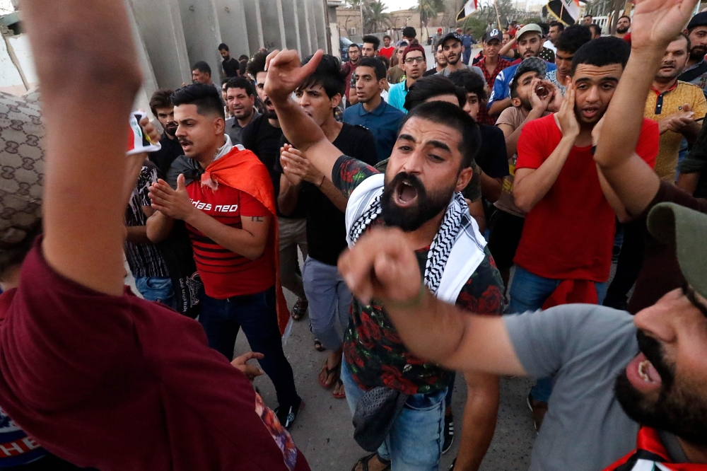 Iraqi men demonstrate in the southern oil-rich city of Basra, the heart of recent protests against power shortages, graft and other social ills, on August 10, 2018 Iraq has been gripped by protests over power outages, unemployment, state mismanagement and a lack of clean water. The demonstrations erupted in the neglected southern province of Basra, home to Iraq's only sea port, before spreading north including to Baghdad. / AFP / Haidar MOHAMMED ALI
