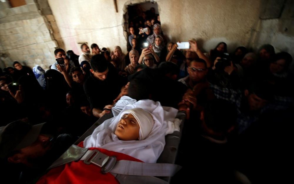 ATTENTION EDITORS - VISUAL COVERAGE OF SCENES OF INJURY OR DEATH Mourners carry the body of Palestinian boy Majdi al-Satari, who was killed by Israeli troops during a protest at the Israel-Gaza border, during his funeral in Rafah in the southern Gaza Strip July 28, 2018. REUTERS/Mohammed Salem  TEMPLATE OUT