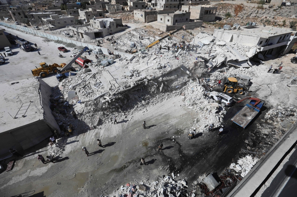 TOPSHOT - Destroyed buildings are seen on August 12, 2018 following an explosion at an arms depot in a residential area in Syria's northern Idlib province city of Sarmada in which 12 people were reportedly killed. / AFP / OMAR HAJ KADOUR
