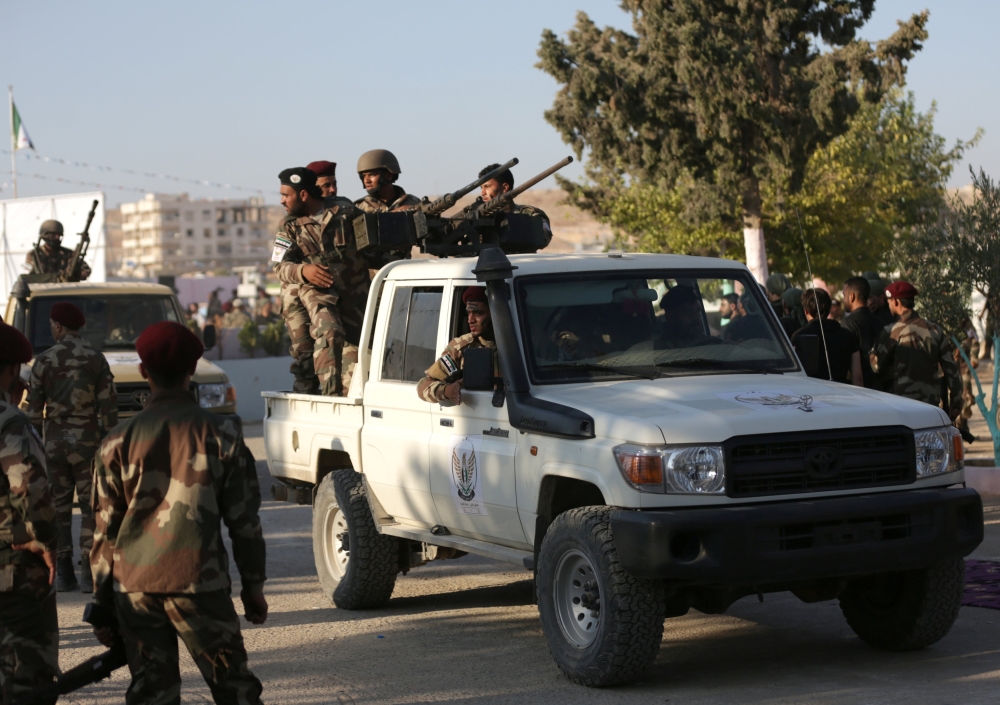 Fighters of National Army, backed by Turkey, stand at a back of a truck in the city of al-Bab, Syria August 5, 2018. Picture taken August 5, 2018. REUTERS/Khalil Ashawi