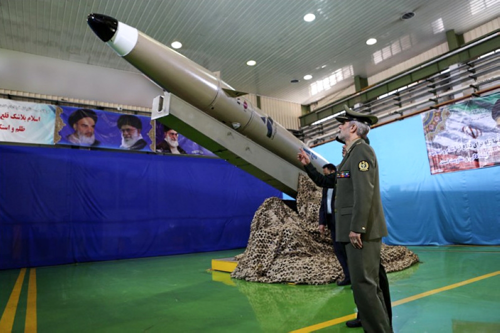 A handout picture released by Iran's Defence Ministry on August 13, 2018 shows Defence Minister, Brigadier General Amir Hatami, standing by the next generation short-range ballistic missile  