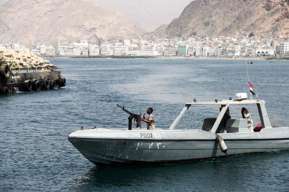 A picture taken on August 8, 2018 during a trip in Yemen organised by the UAE's National Media Council (NMC) shows a Yemeni military patrol boat cruising past the docks in Mukalla, the southeastern capital and supply port of Hadramawt province. / AFP / KARIM SAHIB
