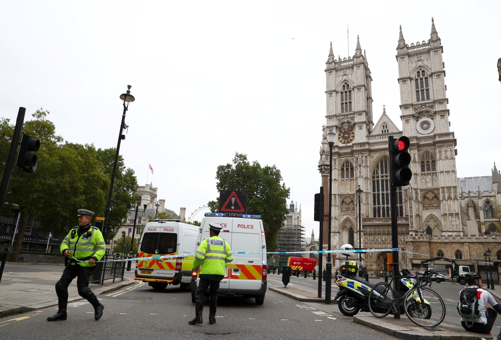 Police officers stand at a cordon after a car crashed outside the Houses of Parliament in Westminster, London, Britain, August 14, 2018. REUTERS/Hannah McKay