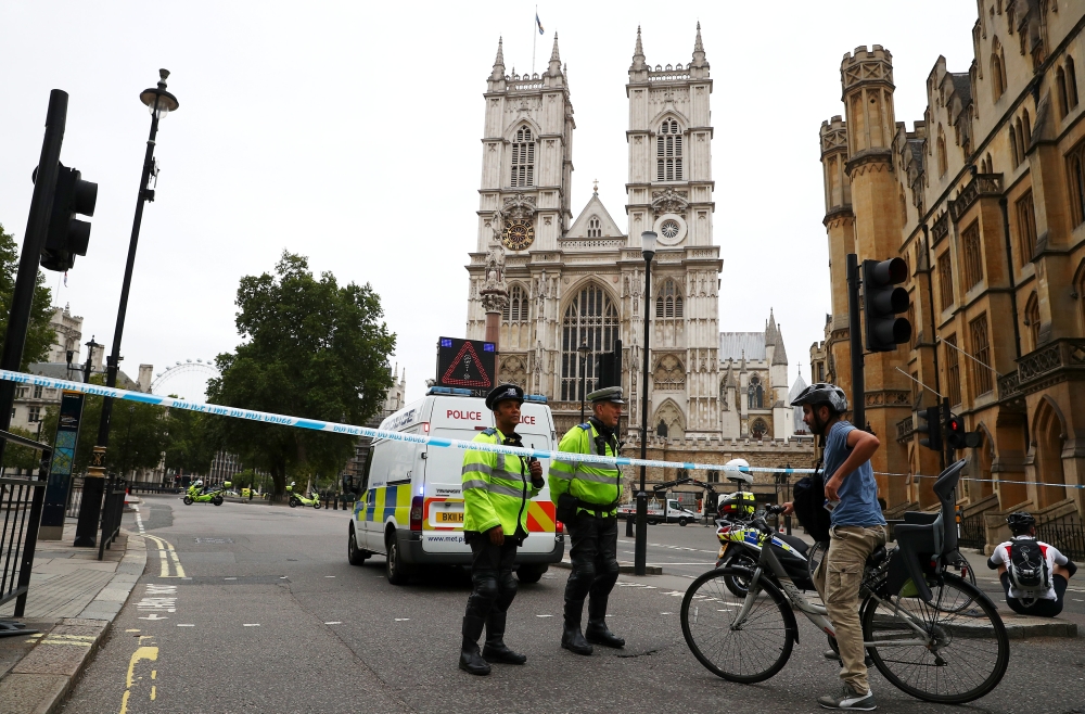 Police officers stand at a cordon after a car crashed outside the Houses of Parliament in Westminster, London, Britain, August 14, 2018. REUTERS/Hannah McKay