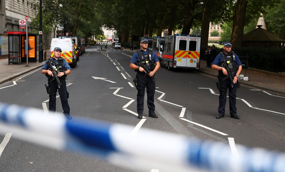 Armed police officers stand at a cordon after a car crashed outside the Houses of Parliament in Westminster, London, Britain, August 14, 2018. REUTERS/Hannah McKay