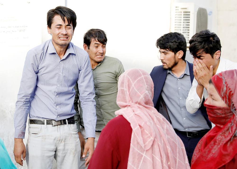 Afghan men mourn after a blast in a hospital in Kabul, Afghanistan August 15, 2018. REUTERS/Mohammad Ismail