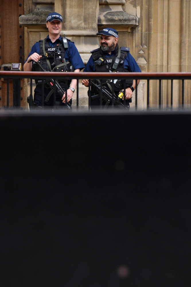 Armed police are seen outside the Houses of Parliament in central London on August 15, 2018 close to the scene of a suspected terror attack on August 14.  The man arrested for driving into a barrier protecting the Houses of Parliament in a suspected terror attack was a Briton of Sudanese origin from Birmingham, media reports said on August 15. Three people were injured when the silver Ford Fiesta drove into cyclists before crashing to a halt outside the House of Lords early on Tuesday morning.
 / AFP / BEN STANSALL
