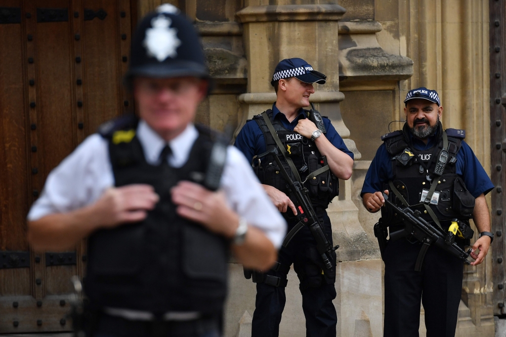 Armed police are seen outside the Houses of Parliament in central London on August 15, 2018 close to the scene of a suspected terror attack on August 14.  The man arrested for driving into a barrier protecting the Houses of Parliament in a suspected terror attack was a Briton of Sudanese origin from Birmingham, media reports said on August 15. Three people were injured when the silver Ford Fiesta drove into cyclists before crashing to a halt outside the House of Lords early on Tuesday morning.
 / AFP / BEN STANSALL
