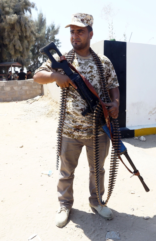 A Libyans security member stands guard on August 23, 2018 near the site of an attack on a checkpoint in the city of Zliten, 170 km east of the capital Tripoli. An attack on a checkpoint between the Libyan capital and the town of Zliten killed four soldiers of the UN-backed unity government on today, the town's mayor said. / AFP / Mahmud TURKIA
