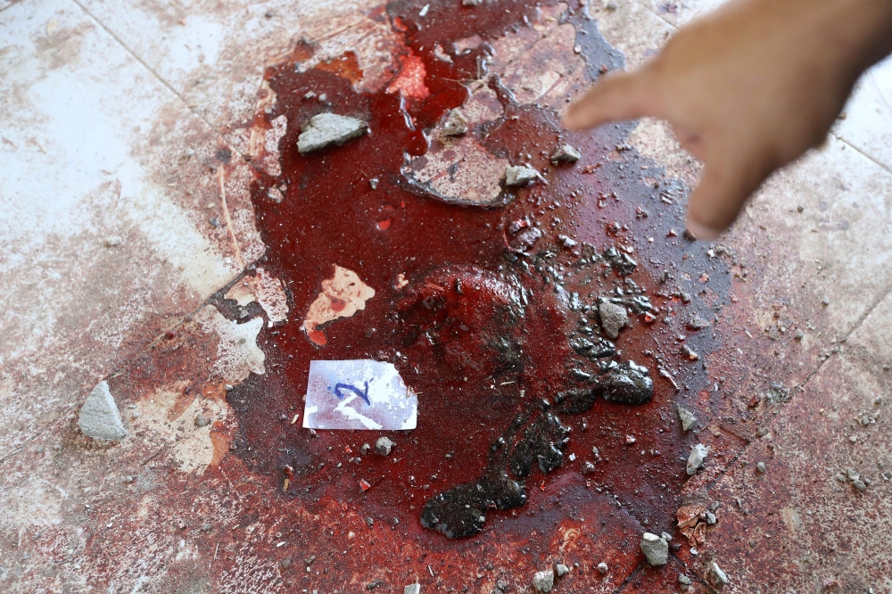 EDITORS NOTE: Graphic content / A member of the Libyan security forces points to a trail of blood on August 23, 2018 at the site of an attack on a checkpoint in the city of Zliten, 170 km east of the capital Tripoli. An attack on a checkpoint between the Libyan capital and the town of Zliten killed four soldiers of the UN-backed unity government on today, the town's mayor said. / AFP / Mahmud TURKIA
