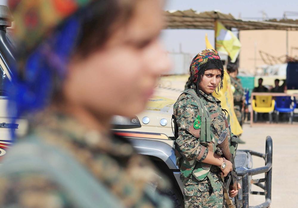 



جندية من وحدات حماية المرأة (YPJ) التابعة لقوات سورية الديمقراطية، ضمن القوات المنتشرة في جنوب مدينة الحسكة السورية، أمس. (أ. ف. ب)