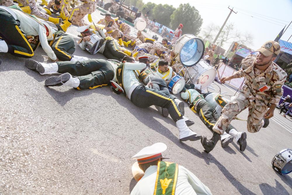 



أعضاء من الفرقة العسكرية الموسيقية أثناء سقوطهم على الأرض خلال الهجوم على العرض العسكري في الأحواز.(أ. ف. ب)