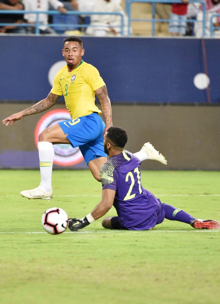 Brazil's forward Gabriel Jesus (L) scores a goal past Saudi Arabia's goalkeeper Mohammed Al-Owais during the friendly football match between Saudi Arabia and Brazil at the King Saud University Stadium in Riyadh on October 12, 2018.  / AFP / FAYEZ NURELDINE
