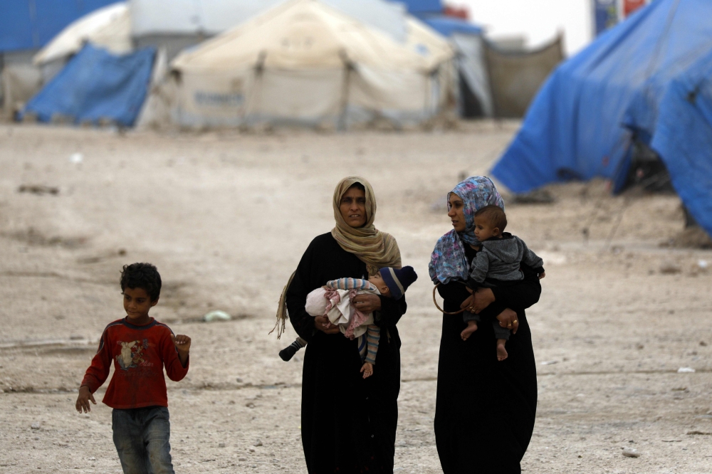 Displaced Syrians, from the eastern city of Deir Ezzor and Raqa who were forced to leave by the war against the Islamic State (IS) group, are pictured walking around at the Ain Issa camp on October 17, 2018. Tens of thousands fled their homes in and around Raqa in the months that led up to US-backed forces ousting the jihadists from the northern city in October 2017.
One year on, most returned, but thousands of others from destroyed homes remain at a camp for the displaced in Ain Issa, around 50 kilometres (30 miles) north of the ravaged city.
Families still reside in flimsy white tents, often with brightly coloured laundry slung out to dry on their guy ropes. / AFP / Delil souleiman
