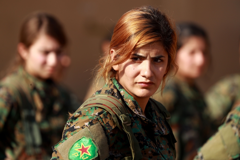 Fighters from the Syrian Democratic Forces (SDF), participate in a military parade during the funeral of a fellow fighter, killed in an offensive by the Islamic State (IS) group against an SDF position, in the Kurdish-controlled city of Qamishly in northeastern Syria, on November 11, 2018.   The Kurdish-led force SDF, joint Arab-Kurdish units backed by the US-led anti-jihadist coalition said today that it was resuming its offensive against the Islamic State (IS) group in eastern Syria. They had announced a suspension to their operation on October 31 after Turkey shelled Kurdish militia posts in northern Syria.
 / AFP / Delil SOULEIMAN
