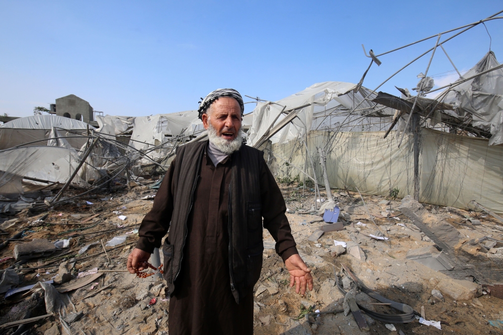 A Palestinian man gestures in front of a building damaged by an Israeli air strike earlier this week in Rafah in the southern Gaza Strip on November 14, 2018. A ceasefire held today after the worst escalation between Israel and Gaza militants since a 2014 war, but the situation remained volatile and the deal provoked sharp disagreement within the Israeli government. / AFP / SAID KHATIB
