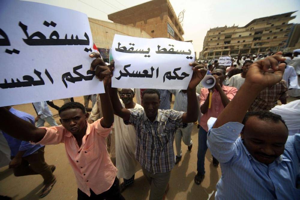 Sudanese and Egyptian Islamist supporters of deposed Egyptian President Mohamed Mursi shout slogans during a rally after taking part in Jumma prayers (Friday prayers) to protest against the recent violence in Egypt, in Khartoum August 16, 2013. The signs read, «Down down military rule». REUTERS/Mohamed Nureldin Abdallah (SUDAN - Tags: CIVIL UNREST POLITICS)