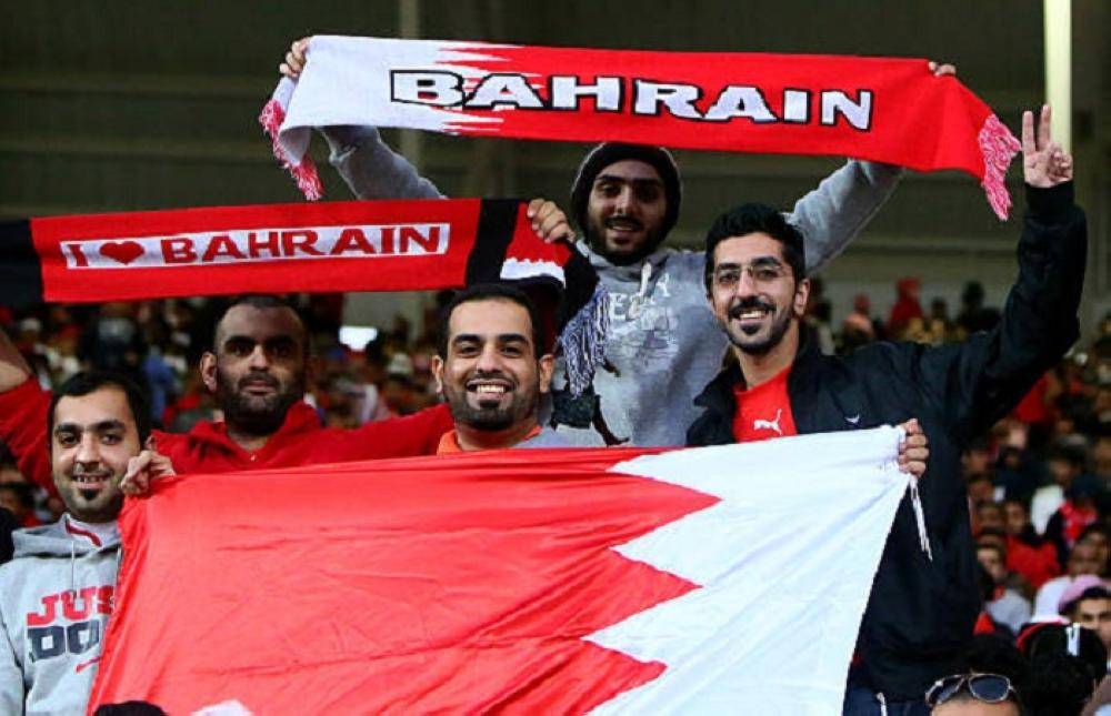 Bahraini fans hold their national flag as they cheer on their team prior the start of Bahrain's football match against Qatar in the 21st Gulf Cup in Manama on January 11, 2013. AFP PHOTO/MARWAN NAAMANI        (Photo credit should read MARWAN NAAMANI/AFP/Getty Images)