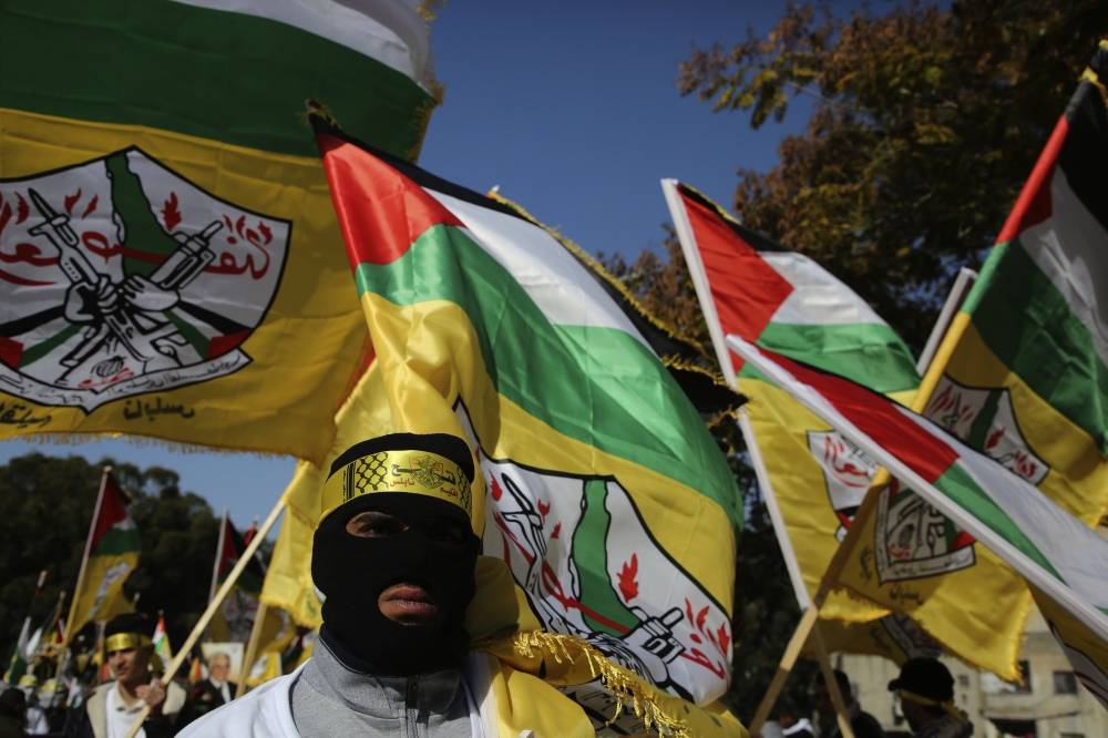 Supporter of the Palestinian Fatah movement wave flags during a rally marking the 54th anniversary of the creation of the political party, in the occupied West Bank city of Nablus on January 3, 2019. / AFP / Jaafar Ashtiyeh 