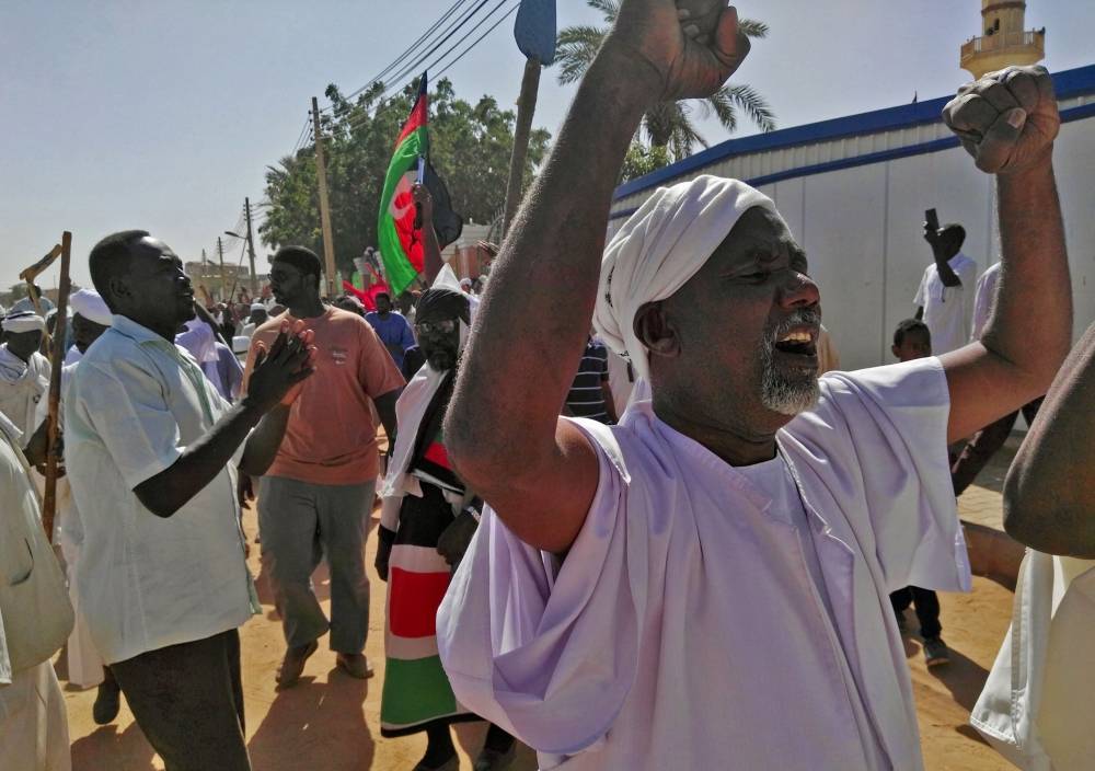 Sudanese men shout slogans during an anti-government protest following Friday noon prayers on January 18, 2019 outside a mosque in the capital Khartoum. Deadly protests have rocked Sudan since they first erupted on December 19 after a government decision to raise the price of bread. The rallies have since escalated into broader demonstrations against President Omar al-Bashir's three decades of iron-fisted rule and triggered clashes with the security forces.
/ AFP / - 