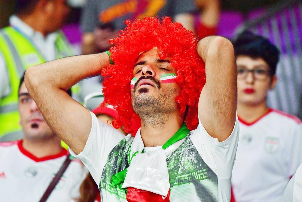 An Iran supporter reacts to their defeat during the 2019 AFC Asian Cup semi-final football match between Iran and Japan at the Hazza Bin Zayed Stadium in Abu Dhabi on January 28, 2019. / AFP / Giuseppe CACACE
