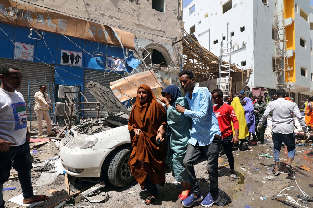 A Somali man evacuate women from the scene where a car bomb exploded at a shopping mall in Mogadishu, Somalia February 4, 2019. REUTERS/Feisal Omar