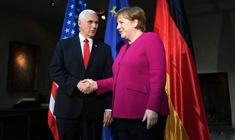 German Chancellor Angela Merkel (R) shakes hands with US Vice President Mike Pence during a photo call at the 55th Munich Security Conference in Munich, southern Germany, on February 16, 2019. The 2019 edition of the Munich Security Conference (MSC) takes place from February 15 to 17, 2019. / AFP / Christof STACHE 